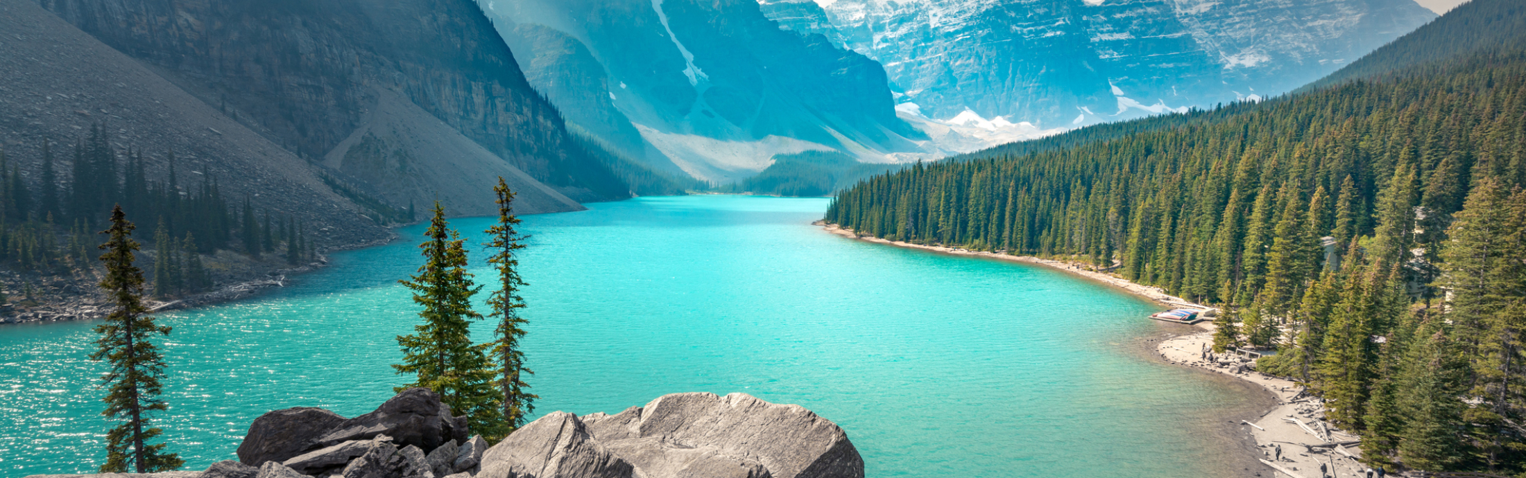 A picturesque lake in Banff surrounded by mountains and trees.