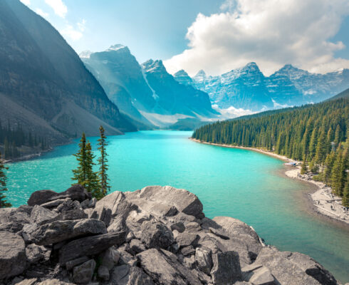 A picturesque lake in Banff surrounded by mountains and trees.
