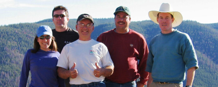 The Ecometrix team stand in front of a mountain range.