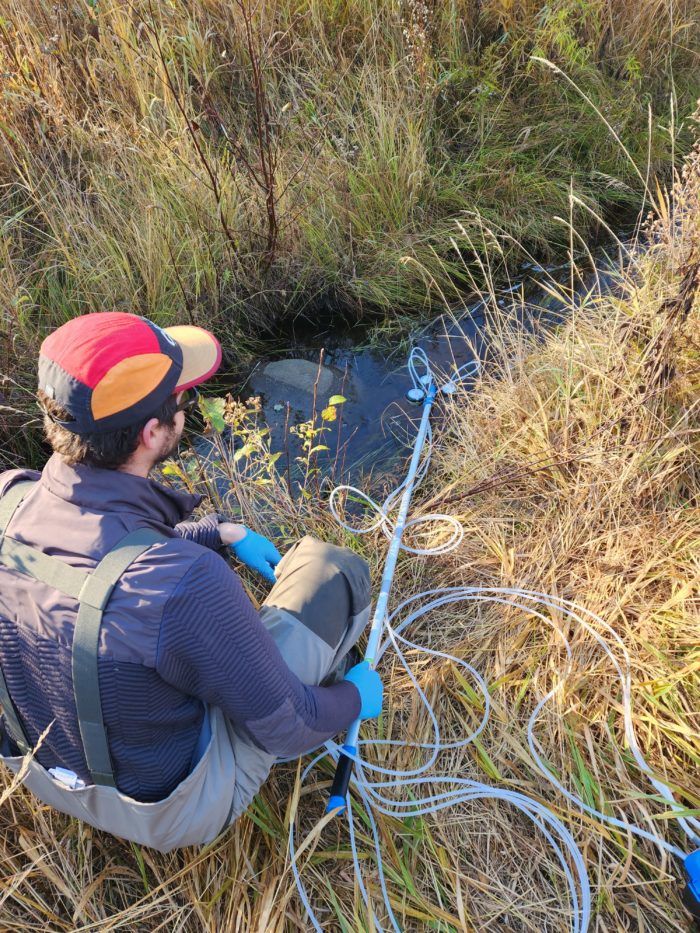 A scientist collecting eDNA using high-throughput eDNA filters and pump.