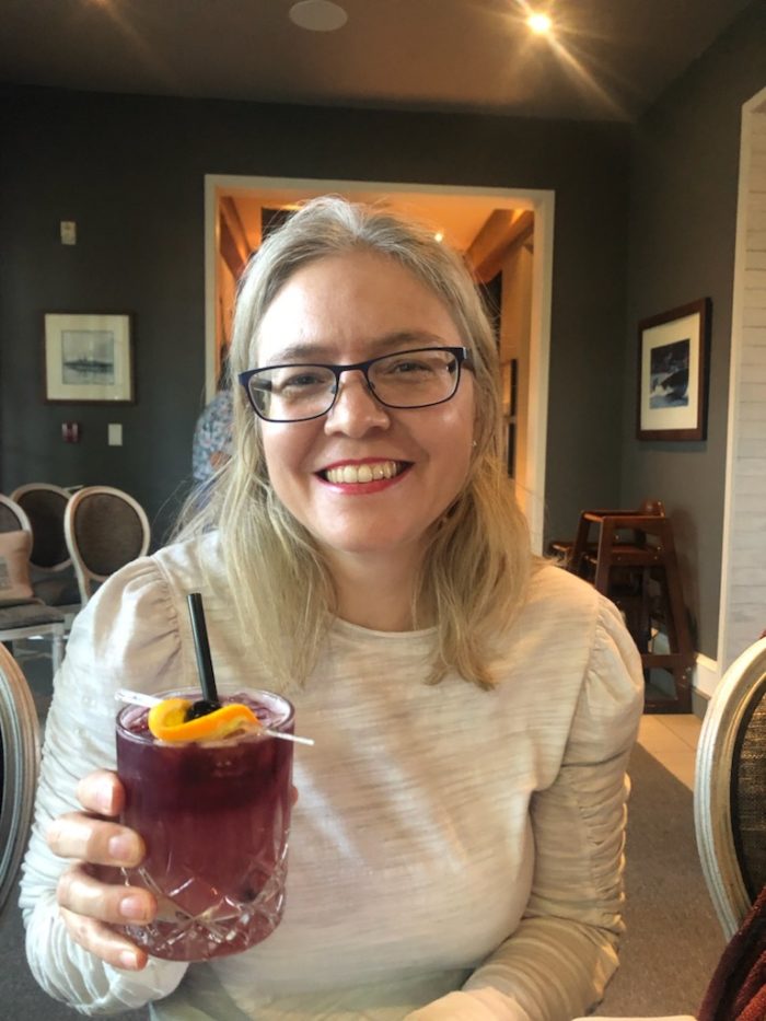 Elizabeth Haack smiling and holding a drink.