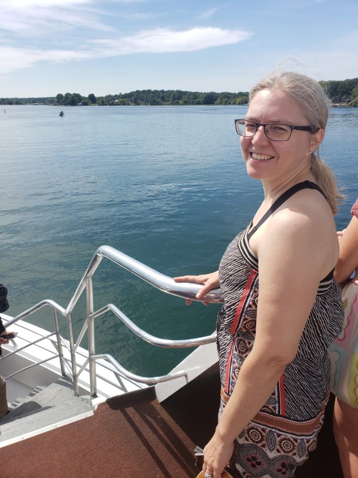 Elizabeth Haack stands on a boat in front of water.